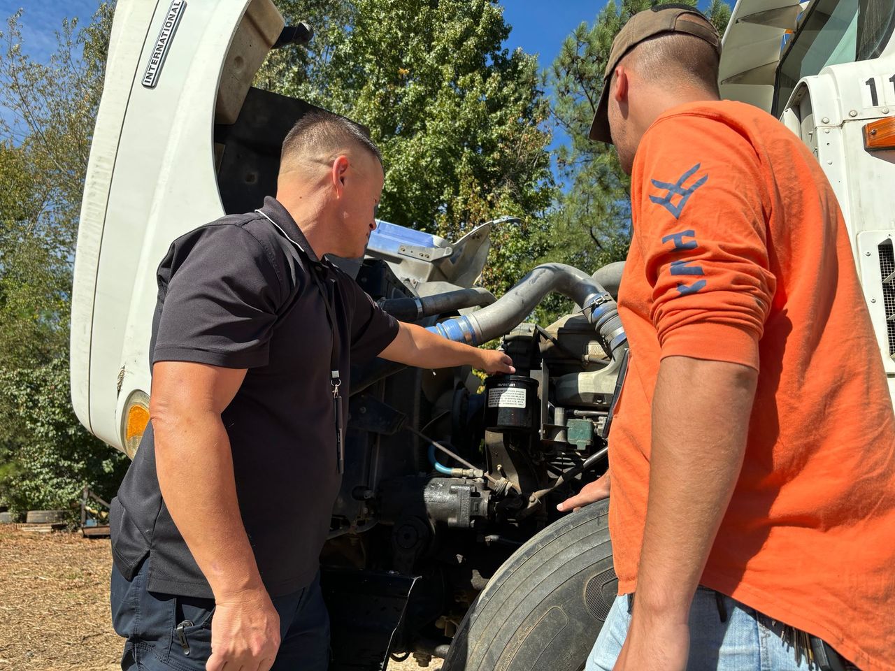 CDL Class B instructor and student inspecting a truck engine